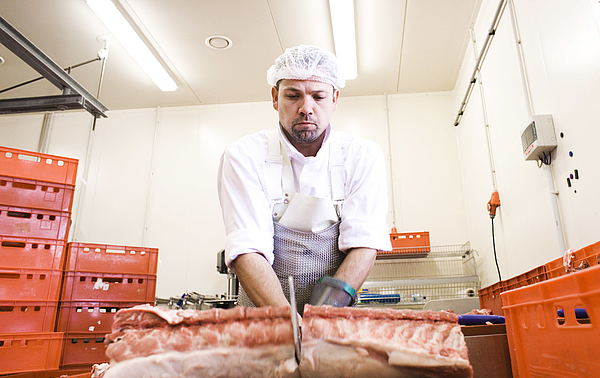 Fleischer bei der Arbeit in einem Schlachtbetrieb